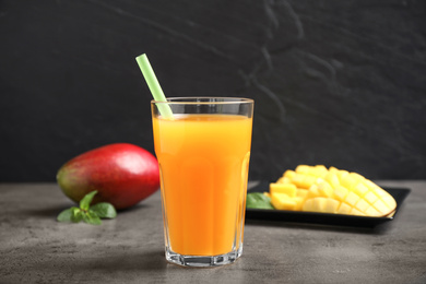 Fresh delicious mango drink on grey table