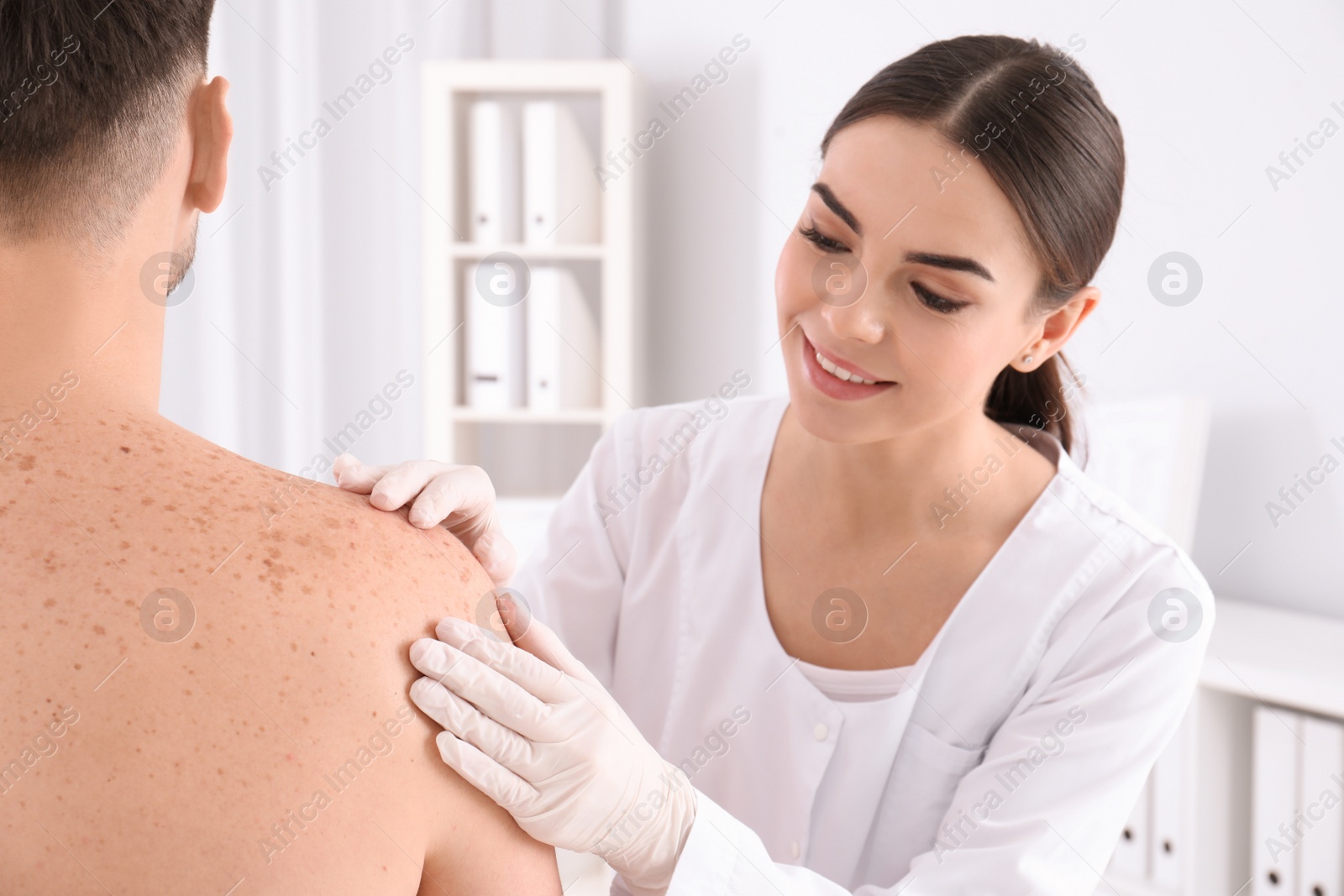 Photo of Doctor examining patient in clinic. Visiting dermatologist