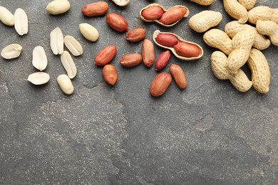 Fresh peanuts on grey table, flat lay. Space for text