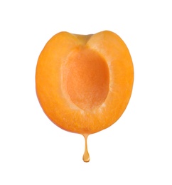 Image of Apricot oil dripping from fresh fruit half on white background