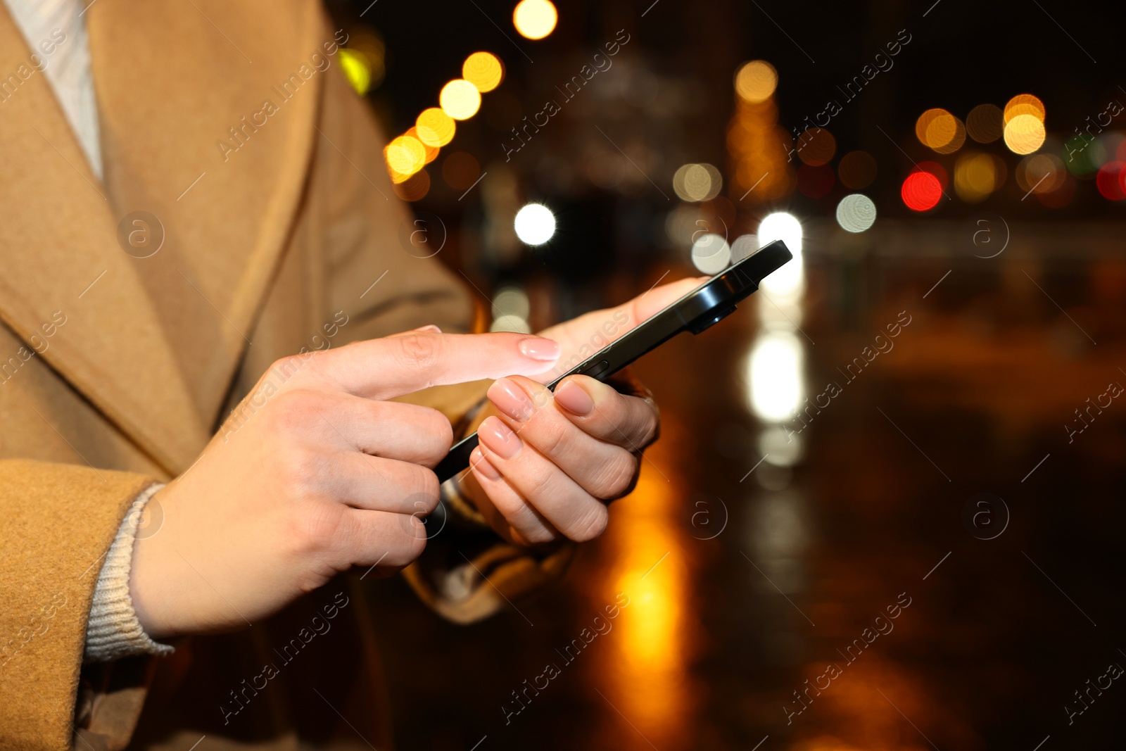 Photo of Woman using smartphone on night city street, closeup. Space for text