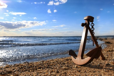 Wooden anchor near river on sunny day
