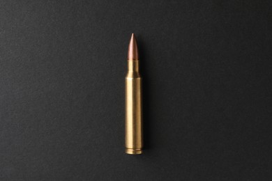 One bullet on black background, top view