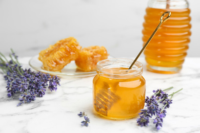 Tasty honey and lavender flowers on white marble table