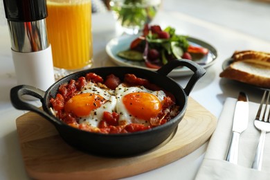 Photo of Tasty Shakshouka served on white table. Traditional Arabic dish