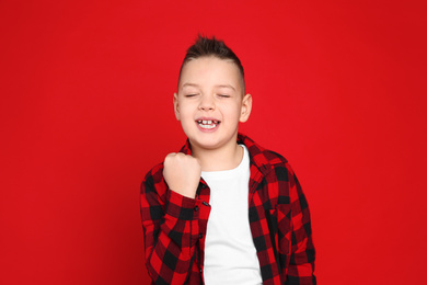 Portrait of emotional little boy on red background