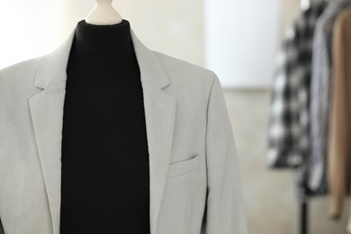 Photo of Mannequin with stylish jacket in tailor shop, space for text
