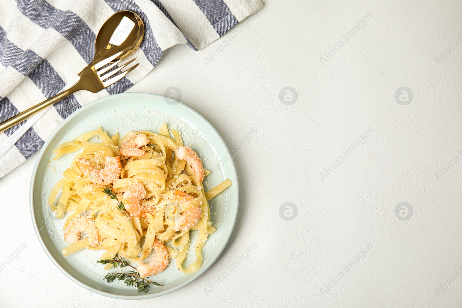 Photo of Delicious pasta with shrimps served on white table, flat lay. Space for text