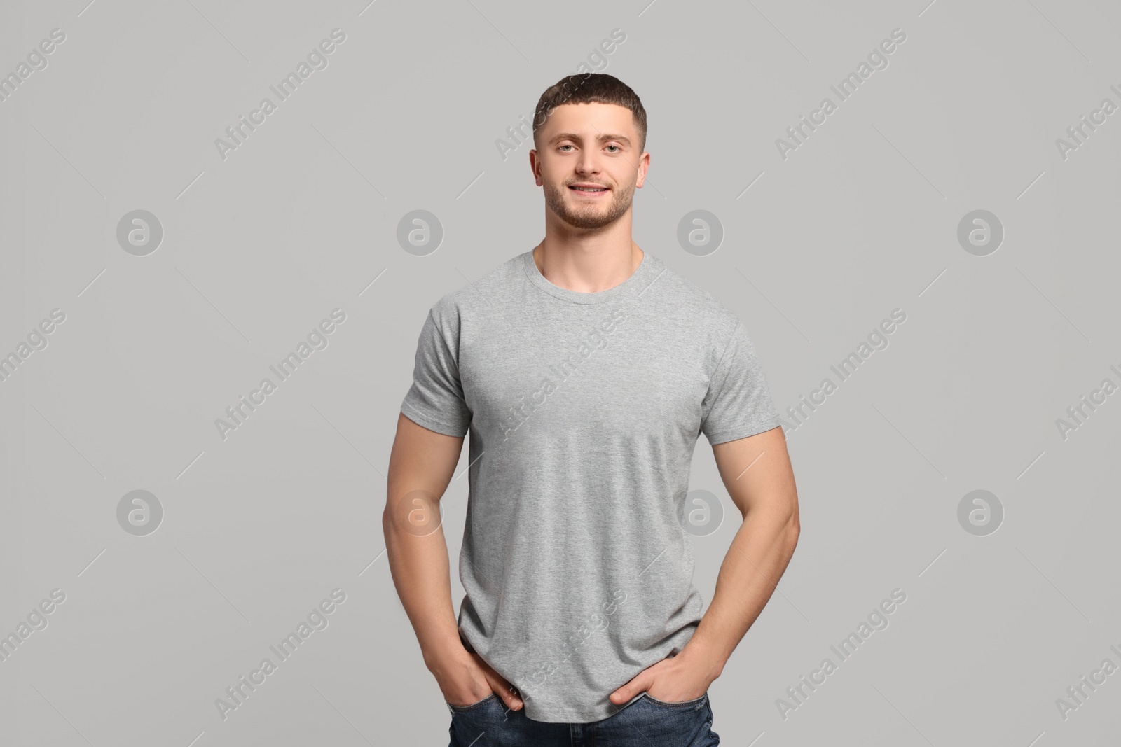 Photo of Man wearing blank t-shirt on light grey background. Mockup for design