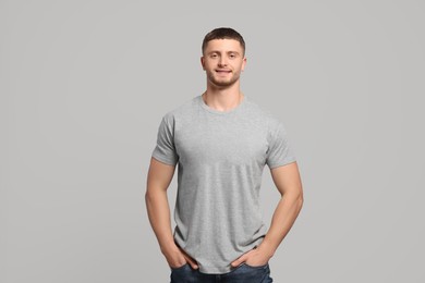 Photo of Man wearing blank t-shirt on light grey background. Mockup for design