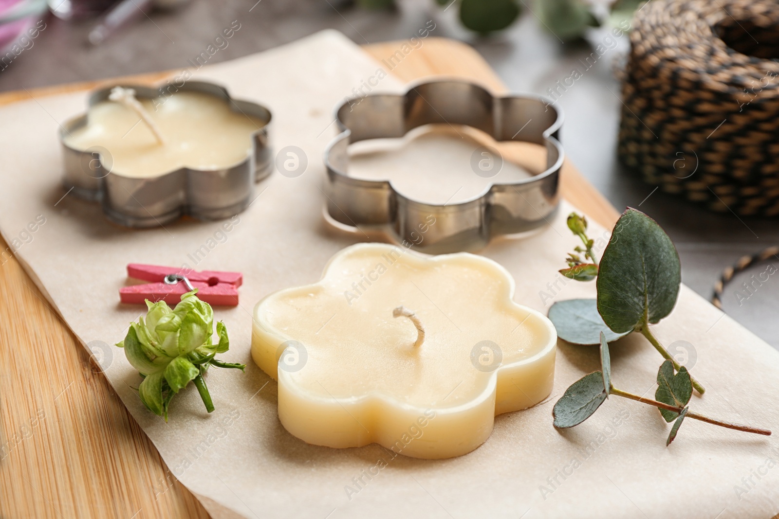 Photo of Wooden board with handmade candles and cutters on table