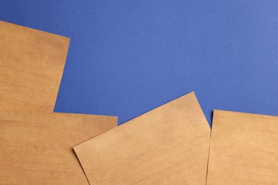 Photo of Sheets of old parchment paper on blue background, flat lay. Space for text