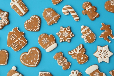 Photo of Different Christmas gingerbread cookies on light blue background, flat lay