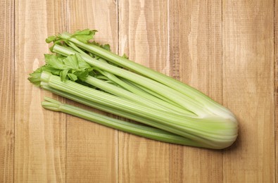 Bunch of fresh green celery on wooden table, top view