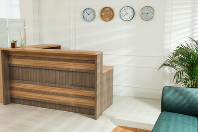 Photo of Hotel lobby interior with wooden reception desk. Stylish workplace