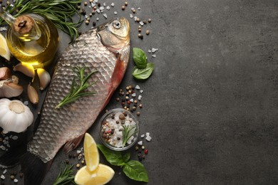 Fresh raw crucian carp and ingredients on grey table, flat lay with space for text. River fish