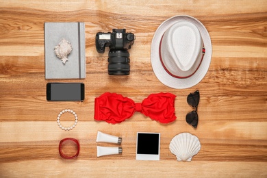 Photo of Flat lay composition with camera and beach objects on wooden background