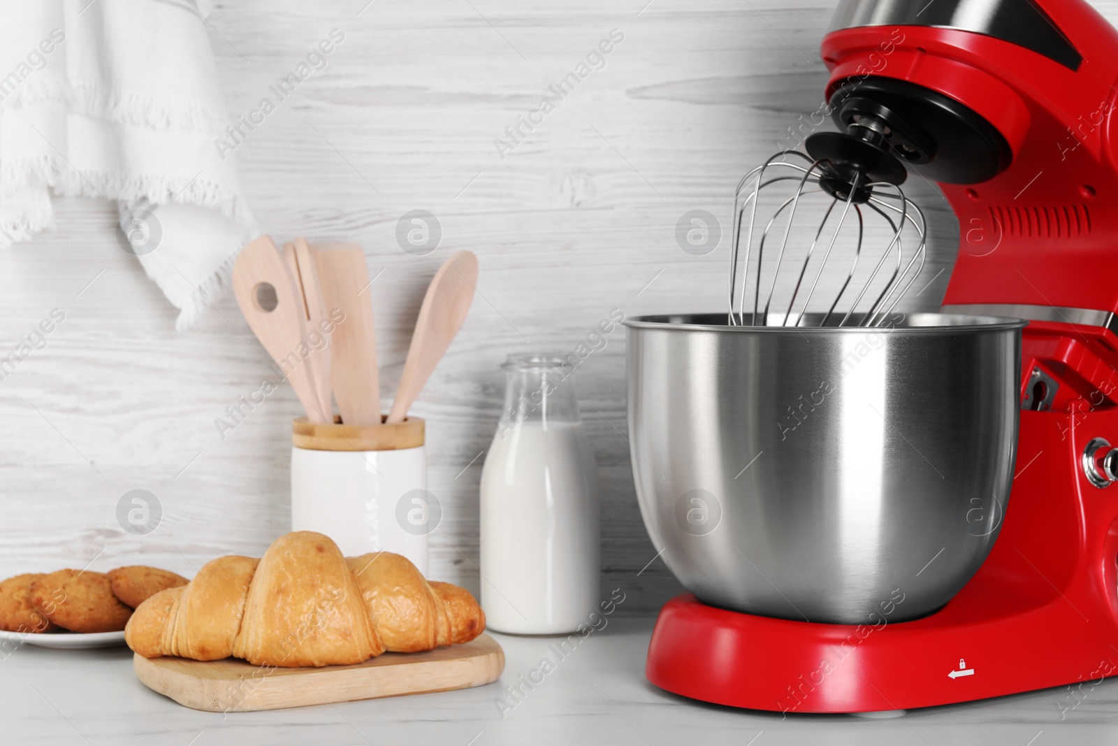 Photo of Modern red stand mixer, croissant, cookies and milk on white marble table