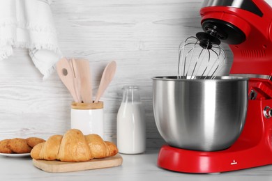 Modern red stand mixer, croissant, cookies and milk on white marble table