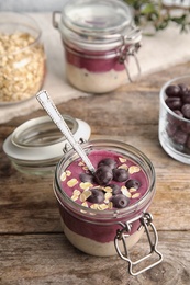 Jar with tasty acai smoothie on wooden table