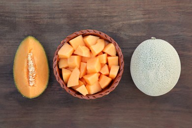 Whole and cut delicious ripe melons on wooden table, flat lay