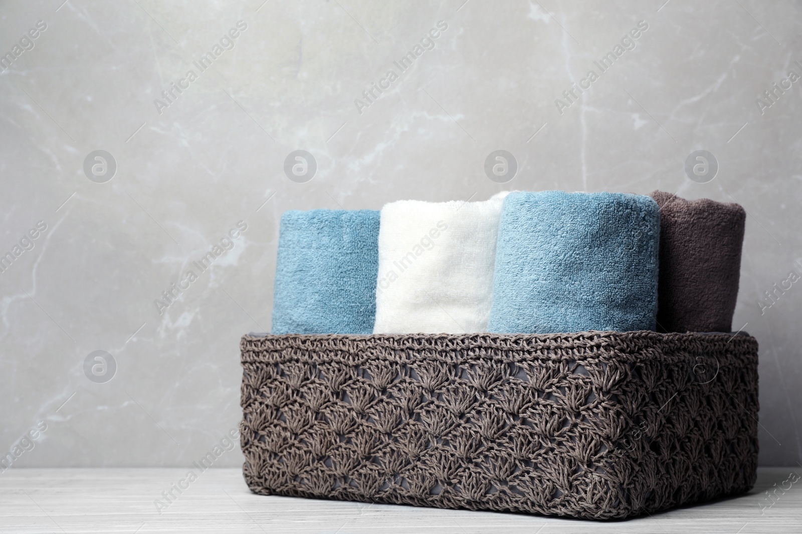 Photo of Basket of fresh towels on table. Space for text