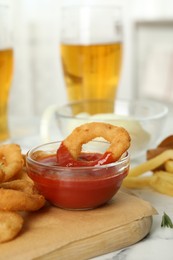 Fried onion rings with sauce served on table