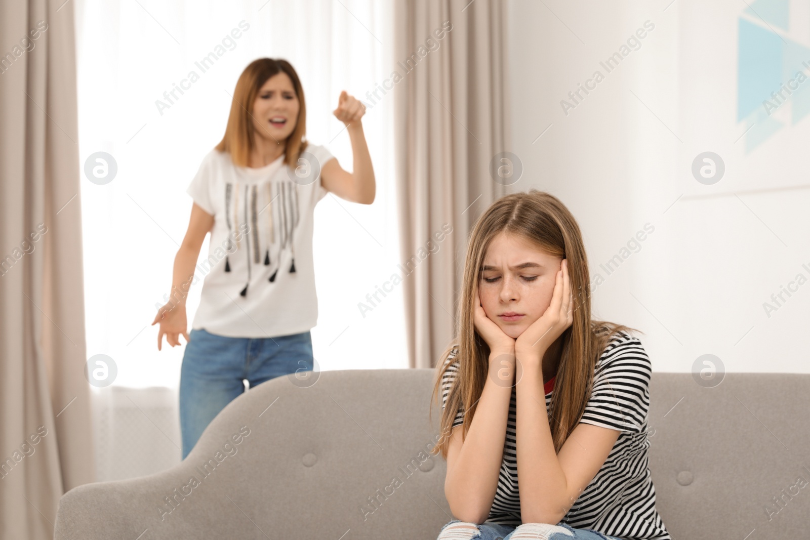 Photo of Mother scolding her teenager daughter at home