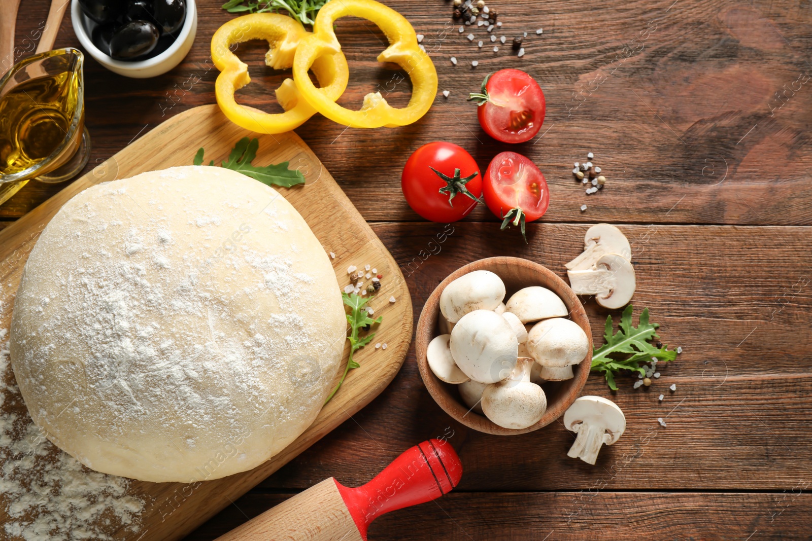 Photo of Flat lay composition with dough and fresh pizza ingredients on wooden table. Space for text