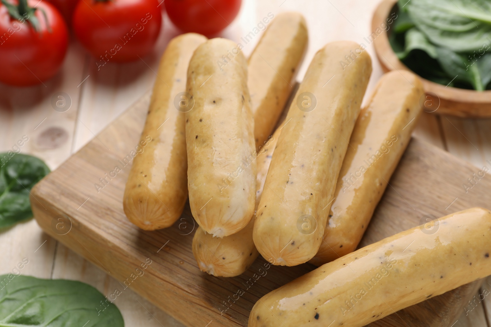 Photo of Raw vegan sausages on wooden board, closeup