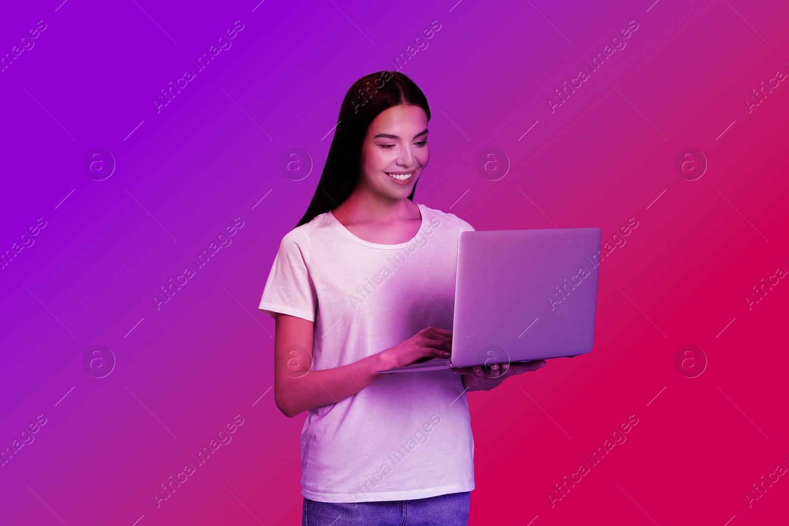 Image of Beautiful woman with laptop in neon lights