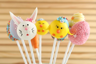 Photo of Different delicious sweet cake pops on wooden background. Easter holiday