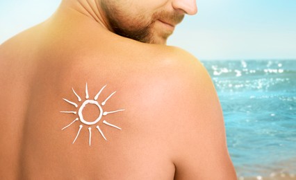 Image of Sun protection. Man with sunblock on his back near sea, closeup