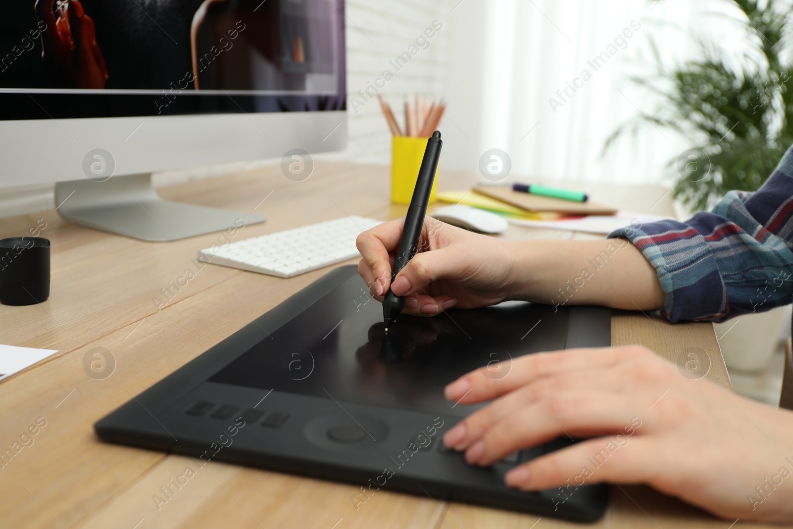 Photo of Professional designer working on graphic tablet at desk, closeup