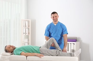 Photo of Doctor working with patient in hospital. Rehabilitation physiotherapy