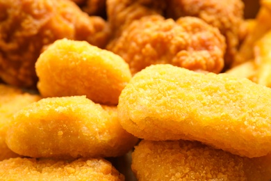 Tasty fried chicken nuggets as background, closeup