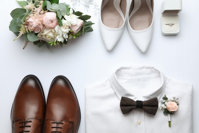 Photo of Composition with wedding shoes for bride and groom on white background, top view