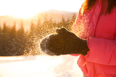 Photo of Young woman having fun outdoors on snowy winter day, closeup