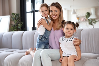 Photo of Cute little girls with their mother in living room