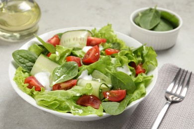 Photo of Delicious vegetable salad served on light grey table, closeup