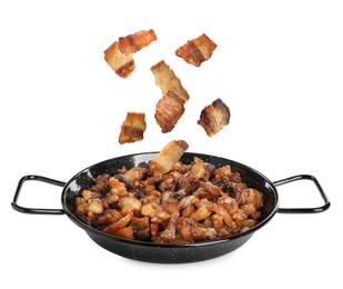 Image of Tasty cracklings falling into frying pan on white background. Cooked pork lard