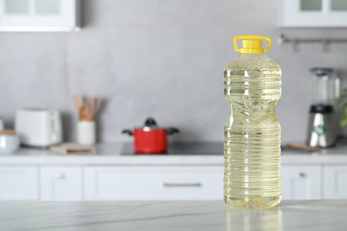 Bottle of cooking oil on white marble table in kitchen. Space for text