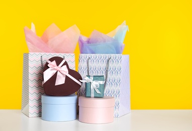 Shopping bags and gift boxes on yellow background