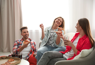 Group of friends eating tasty pizza at home