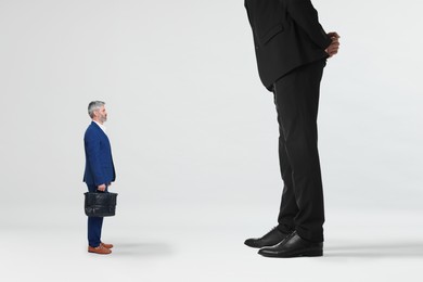 Image of Giant boss and small man on light background