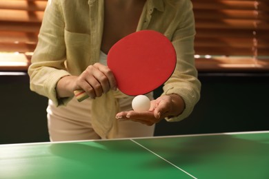 Photo of Woman playing ping pong indoors, closeup view