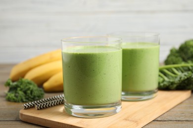 Photo of Tasty fresh kale smoothie on wooden table, closeup