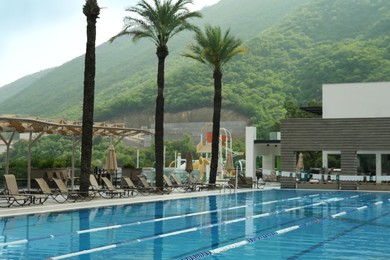 Photo of Swimming pool and sunbeds at luxury resort