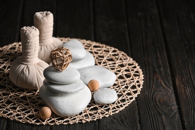 Photo of Composition with spa stones on wooden table