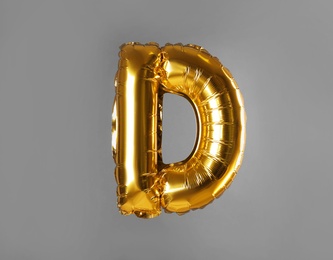 Photo of Golden letter D balloon on grey background
